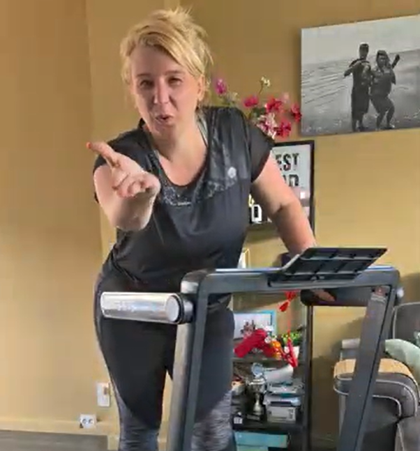 Nadine macht Schritte auf einem kompakten Laufband in ihrem Wohnzimmer, während ihre Kinder vergnügt spielen